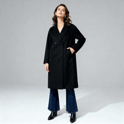 Woman wearing a black coat and blue jeans on a gray background